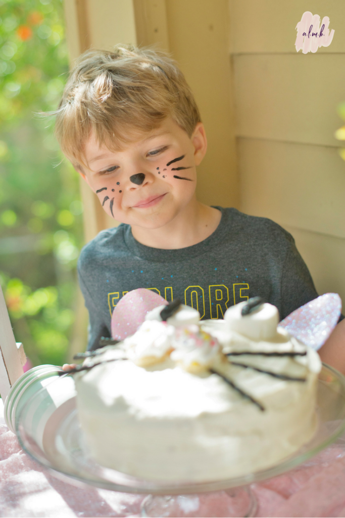 A friend checks out the homemade pretty kitty birthday cake. | ALMB
